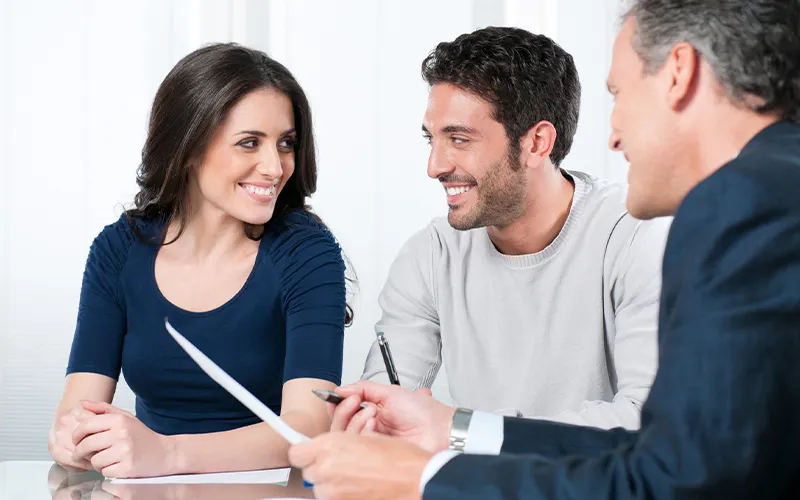 A girl and two guys are smiling while discussing something