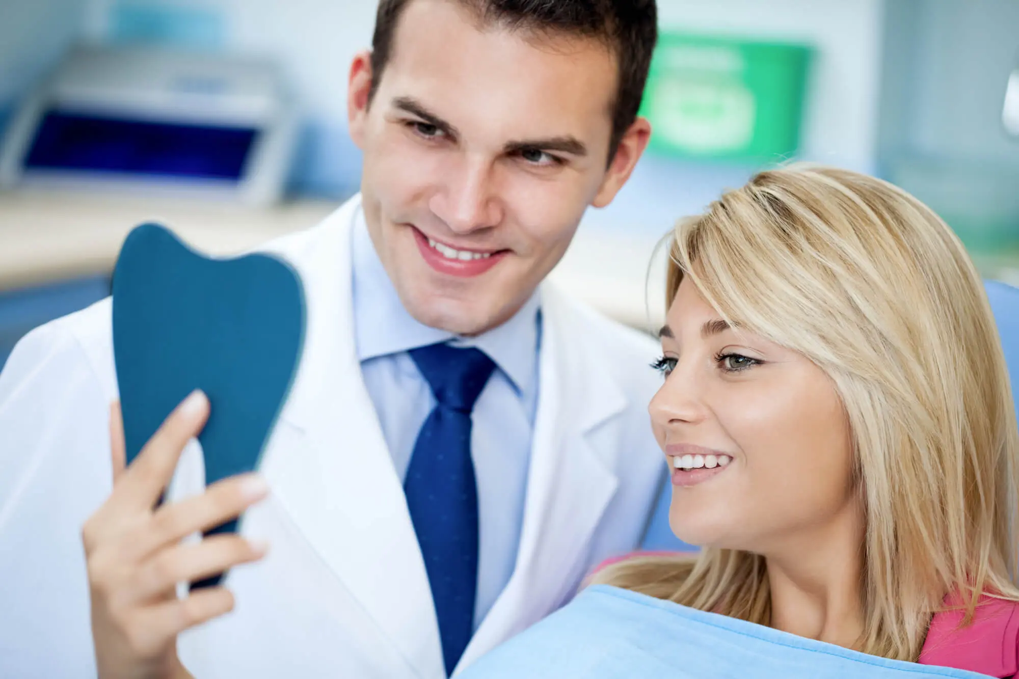 The doctor and patient look in the mirror after dental procedures.